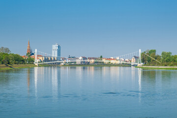Pedestrian bridge over the Drava river and skyline of city of Osijek, Croatia