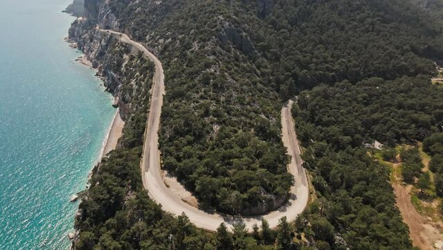 aerial drone footage of beautiful scenic landscape of Marmaris peninsula, mountains and hills with green woods and curved road to Datca destination. peninsula surrounded Aegian and Mediterranean seas.