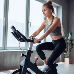 Peel and stick wall murals Fitness young female on an exercise bike. Weight loss concept