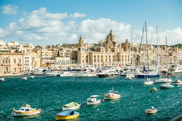 Fototapeta na wymiar Marina with sailboats and yachts in front of a historical backdrop. The old town of Valletta