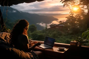 Poster Young woman freelancer traveler working online using laptop and enjoying the beautiful nature landscape with mountain view at sunrise © Александр Марченко