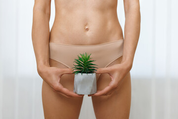 A woman with an cactus in her hands in underwear. The concept of hair removal, smoothness. Concept...