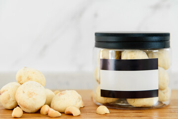 Macadamia nut and cookies in plastic cans on wooden table