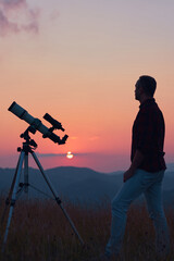Astronomer looking at the skies with a telescope.