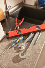 Fototapeta premium Plumber tools for fixing and repairing water tap on the kitchen sink.