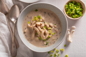 Homemade mushroom shimeji soup with chives and cream.