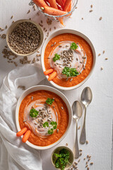 Creamy carrot soup with seeds and cream.