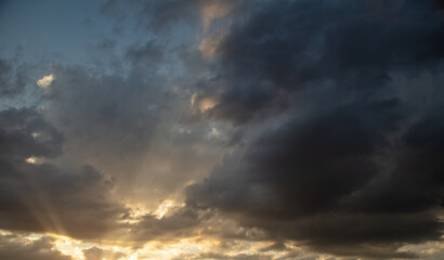 Naklejka na ściany i meble Thunderclouds in the sky at sunset.