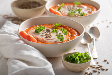 Creamy carrot soup with sunflower seeds and parsley.
