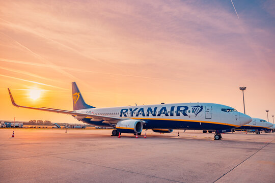 Beautiful sunrise, low cost airline Ryanair airplane tails in front of Budapest Airport terminal. Commercial aircraft seen from the side in the airport runway. Air transportation concept 07.11.23