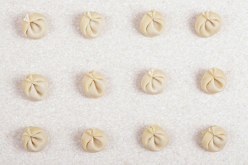 Uncooked dumplings on white table closeup. Homemade dumplings. Top view.