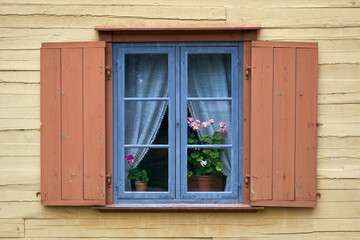 Obraz na płótnie Canvas Vintage rustic window with geranium flowers on the windowsill indoors.