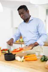 Man prepares a vegetable salad for dinner in a home kitchen