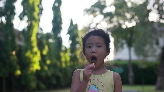 cute little girl enjoy popsicle in the garden.