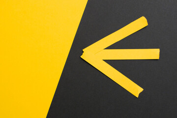Yellow arrow on yellow and black diagonally divided background