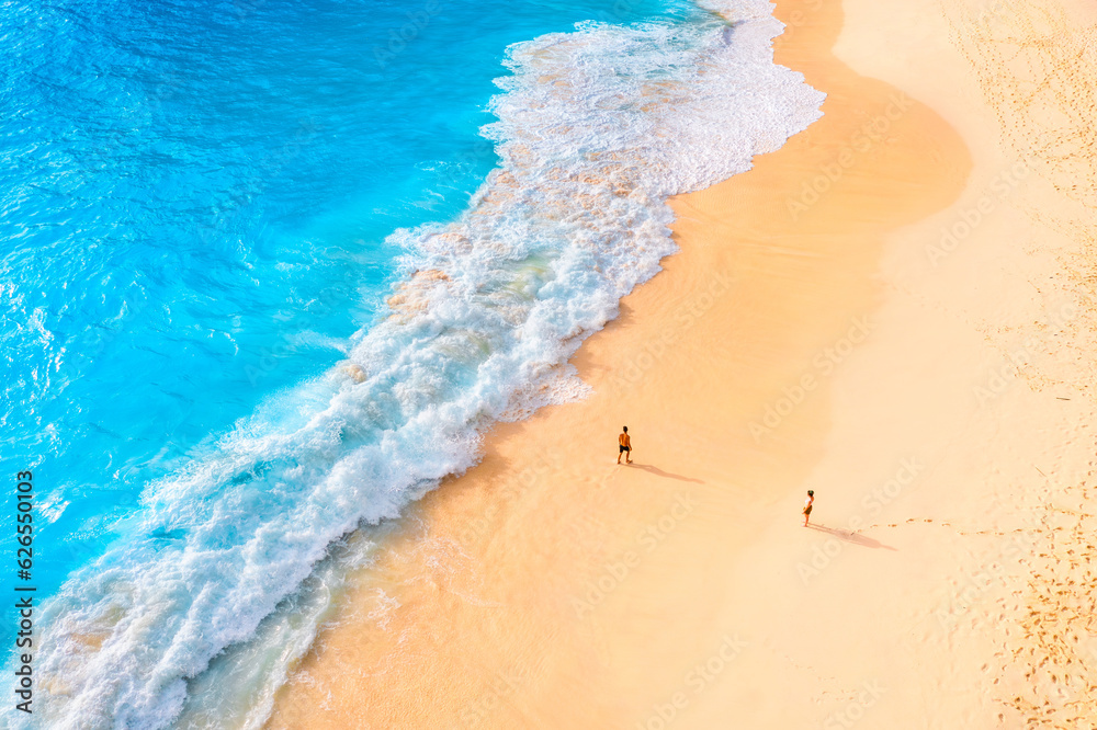 Wall mural an aerial view of the people on the beach. coast as a background from top view. waves and beach. sea