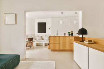 a living room with white walls and wood furniture in the center of the room is a green couch that's next to the