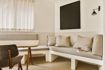 a living room with a couch, table and tv mounted on the wall in it's centerpieces