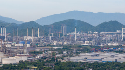Oil refinery plant industry factory zone, oil and gas petrochemical industrial, oil storage tank and pipeline steel on island and moundtainbackground, aerial view