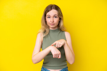Obraz premium Blonde English young girl isolated on yellow background making the gesture of being late