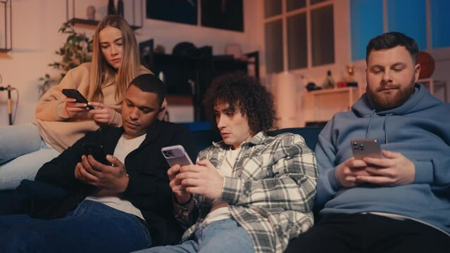 Young people using their smartphones on couch, ignoring real life communication
