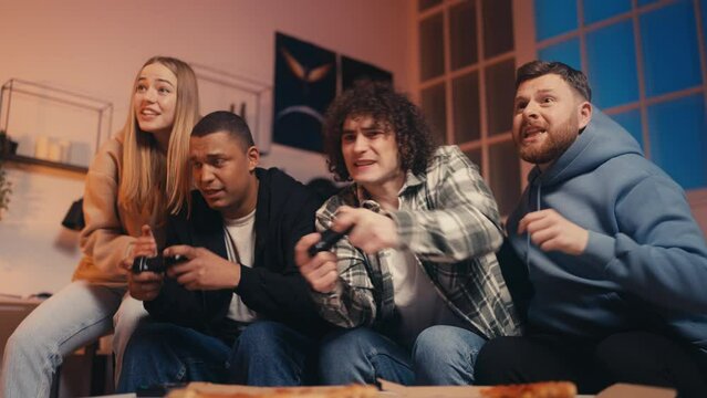 Group of diverse people playing video game, excited friends cheering for guys