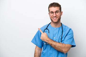Young surgeon doctor caucasian man isolated on white background pointing to the side to present a...