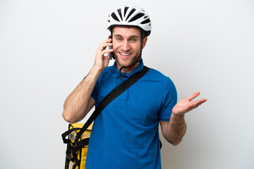 Young caucasian man with thermal backpack isolated on white background keeping a conversation with the mobile phone with someone