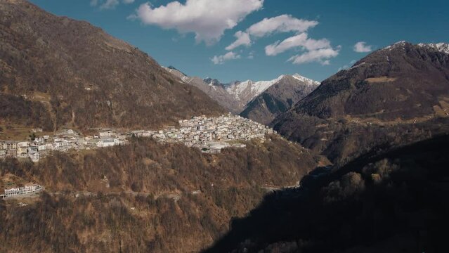 Aerial view of the small village in Valsassina with the snow-capped mountains of the Lombardy Alps in the background.