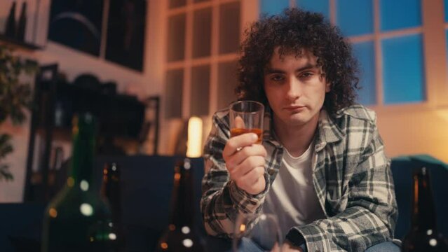 Portrait of funny nerdy guy drinking whiskey, unhealthy lifestyle, partying