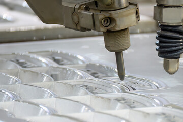 Close-up scene of multi-axis abrasive waterjet cutting machine cutting the aluminum plate.