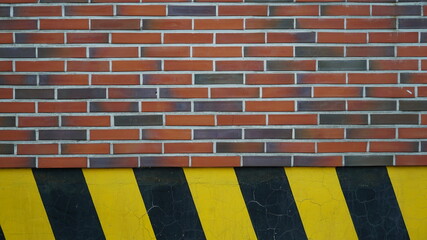 Warning sign wall texture background of red brick and old black yellow stripes pattern