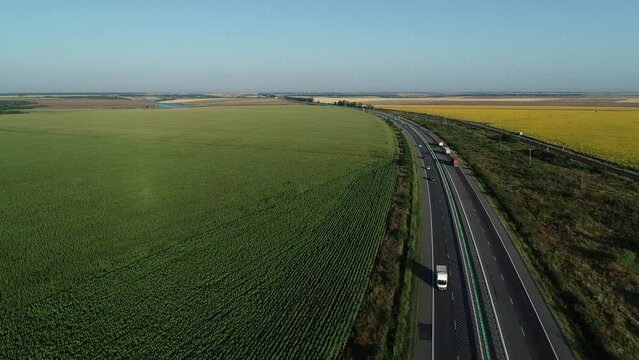 Aerial view at sunrise of A2 Highway motorway road and national railroad between Bucharest and Constanta cities. Amazing beautiful romanian road and railroad. 4k video