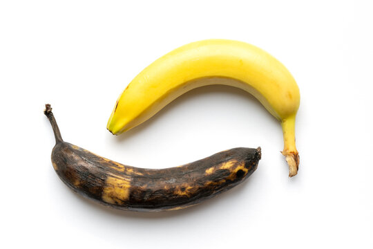 Reife gelbe Banane und &uuml;berreife braune Banane vor weissen Hintergrund mit Schatten