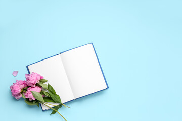 Blank open book and beautiful peony flowers on color background