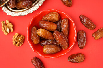 Bowls with dried dates on red background
