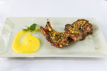 Delicious Italian grilled lamb chop with pistachios topping and sauces