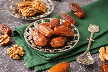 Bowl with dried dates on grey background