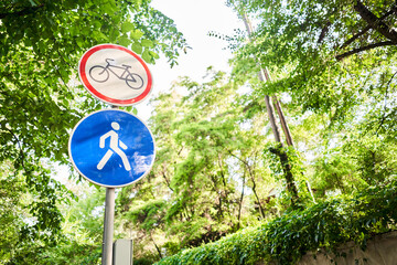 Bike and pedestrian signs in summer. Italy. View of a generic no cycling sign on a pedestrian...