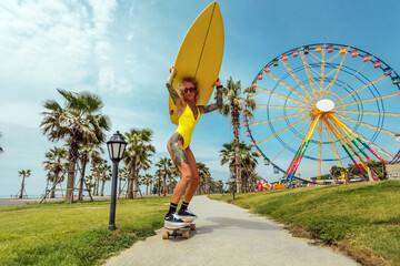 Young woman riding on skate with surf in amusement park to the beach. Street culture, skateboard...