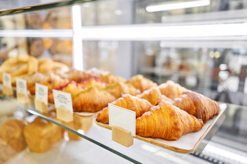 Lot of croissant is fresh and hot in a cafe next to other types of pastries. A variety of fresh pastries in the bakery window. The interior of an Italian restaurant.