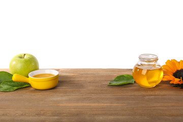 Sweet honey, apple and sunflower on wooden table against white background