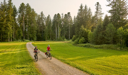 two senior girlfriends having fun during a cycling tour in the Allgau Alps near Oberstaufen, Bavaria, Germany