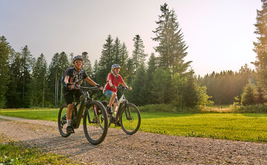 two senior girlfriends having fun during a cycling tour in the Allgau Alps near Oberstaufen,...