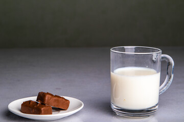 glass of milk with chocolate on black background
