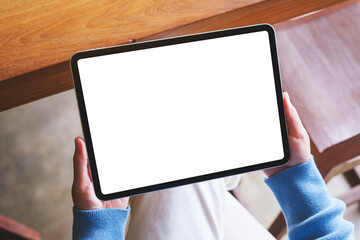 Obraz premium Top view mockup image of a woman holding digital tablet with blank white desktop screen