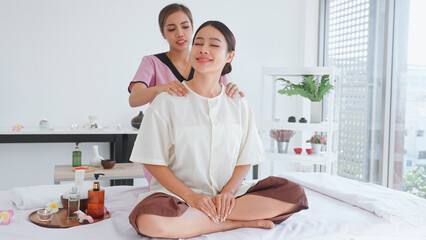 Thai massage for young woman by skilled masseuse.