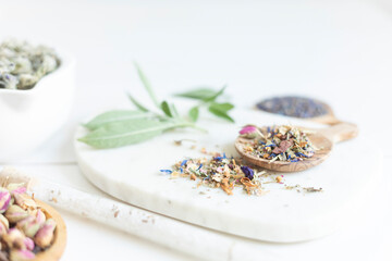 Botanical blends, herbs, essencial oils for naturopathy. Natural remedy, herbal medicine, blends for bath and tea on white wooden table background