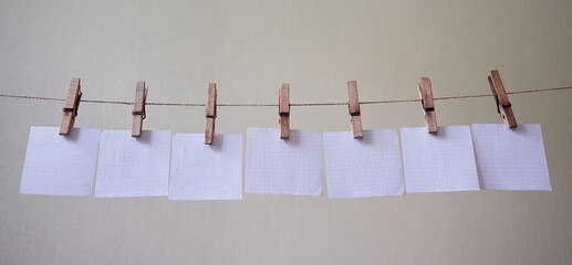 seven checkered note papers hanging on a clipboard