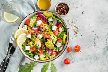 Delicious and healthy green salad of different leaves and vegetables with seeds and olive oil.